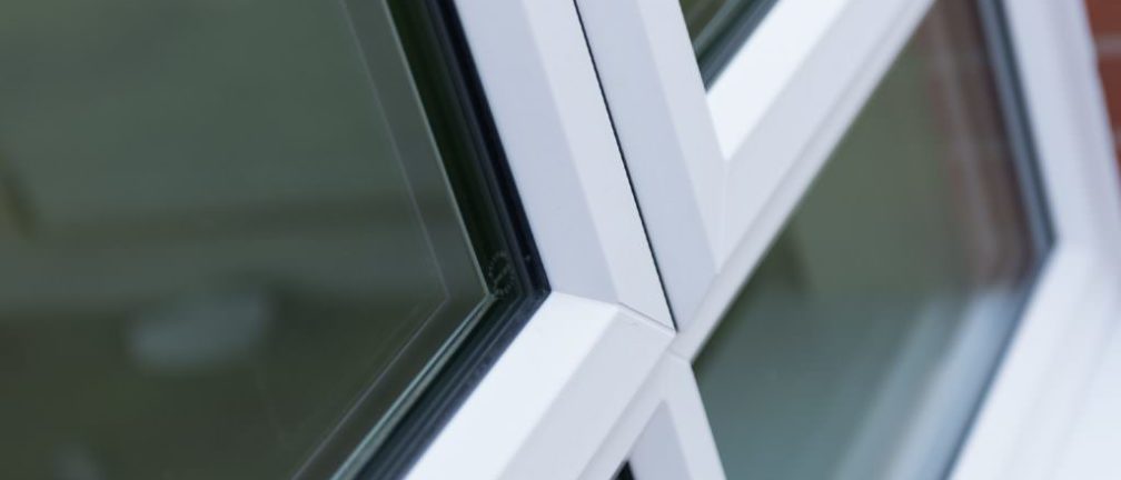 A zoomed photo of a double glazing window with a white frame.