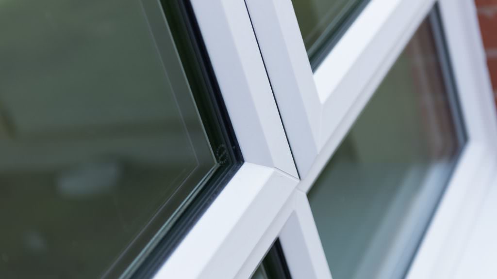 A zoomed photo of a double glazing window with a white frame.